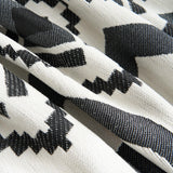Close-up of the black and white geometric fabric folds of the Geometric Boho throw