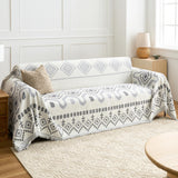 Geometric Boho throw in Gray Geometry over a sofa, side angle with lamp and woven rug