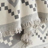 Close-up of the fringed tasseled edge of the Gray Geometry Geometric Boho throw