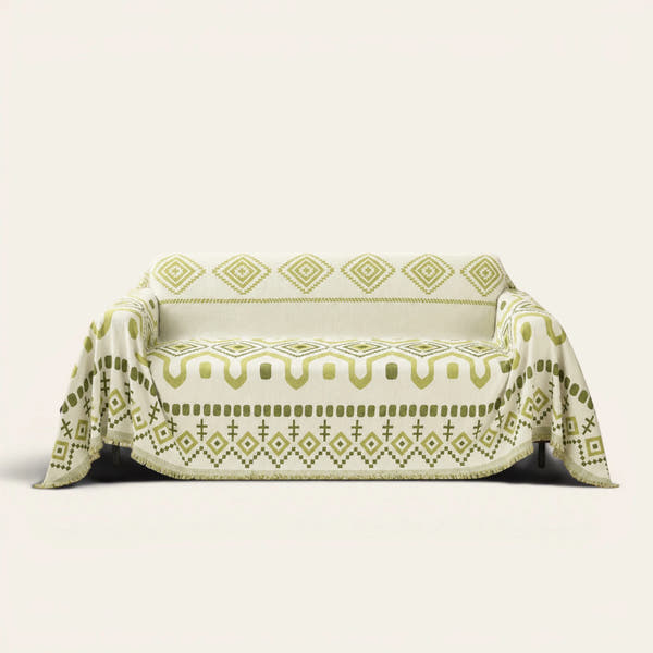 Geometric Boho sofa throw in Green Geometry draped over a couch, front view on ivory background
