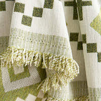 Close-up of the fringed tasseled border of the Green Geometry Geometric Boho throw