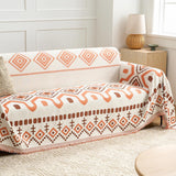 Orange Geometry boho throw on a sofa beside a rattan lamp and bright window