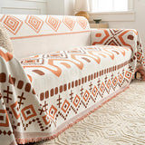 Geometric boho throw styled over a couch with cream rug and rattan lamp