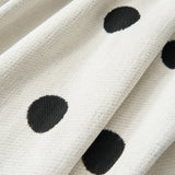 Close-up of the polka dot chenille fabric folds of the Black Boba throw