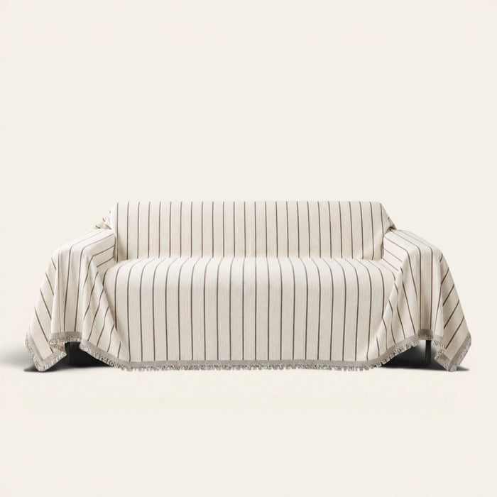 Geometric Chenille sofa throw in Black Linearity over a couch, front view with thin vertical stripes and fringe