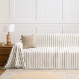Black Linearity striped throw styled on a sofa against a paneled wall with a knit cushion and lamp