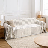 Wider view of the Black Linearity striped throw covering a sofa between two lamps and side tables