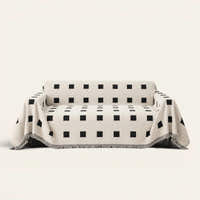 Checkered Onyx Geometric Chenille sofa throw draped over a full couch, front view on ivory background
