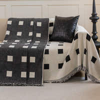 Checkered Onyx Geometric Chenille throw showing its reversible black and cream square sides