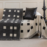 Checkered Onyx Geometric Chenille throw showing its reversible black and cream square sides