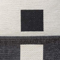 Macro of the Checkered Onyx Geometric Chenille fabric showing woven black squares on cream