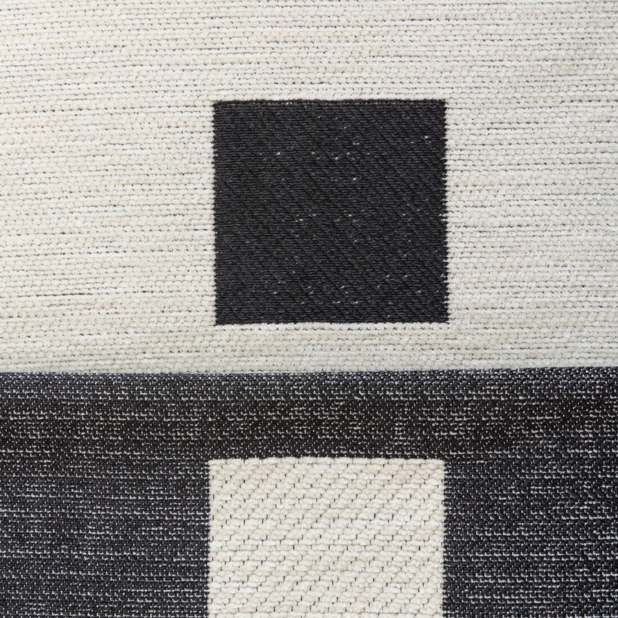 Macro of the Checkered Onyx Geometric Chenille fabric showing woven black squares on cream