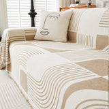Brown Stream Geometric Harmony throw over a sofa with a face-print cushion, close view of the curved line pattern