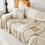 Overhead angle of Brown Stream Geometric Harmony throw spread across a sofa with cushion and tasseled edges