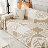Angled view of Brown Stream Geometric Harmony throw over sofa seat and back with line-art cushion and wood cabinet