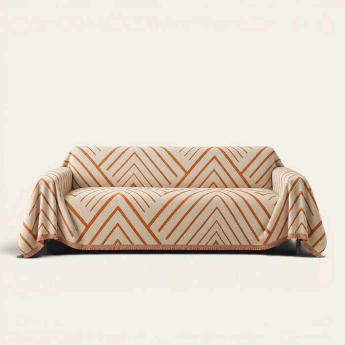 Orange Arrow geometric rust chevron sofa throw draped over a two-seat couch, front view on ivory background
