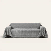 Midnight Hound Houndstitch sofa throw draped over a two-seat sofa, front view on ivory background, black and white houndstooth