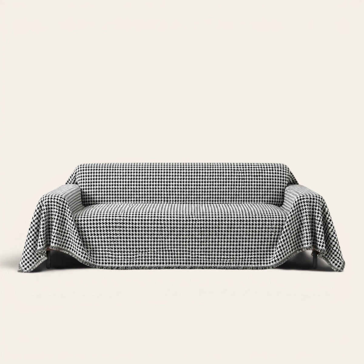 Midnight Hound Houndstitch sofa throw draped over a two-seat sofa, front view on ivory background, black and white houndstooth