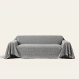 Midnight Hound Houndstitch sofa throw draped over a two-seat sofa, front view on ivory background, black and white houndstooth