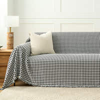 Midnight Hound Houndstitch throw styled on a sofa with a corduroy cushion and wooden lamp in a paneled room