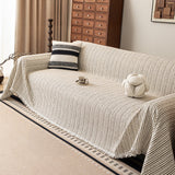 Charcoal Stripe Linear Weave throw covering a sofa with a striped cushion and coffee cup, wood cabinet in a living room