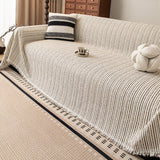 Charcoal Stripe Linear Weave throw over a sofa with striped cushion and knot ball, angled overhead view