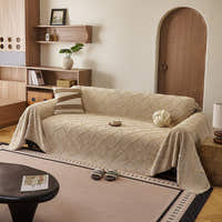 Oat Beige Luxe Diamond throw styled on a sofa with striped and knot cushions