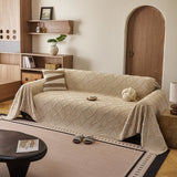 Oat Beige Luxe Diamond throw styled on a sofa with striped and knot cushions