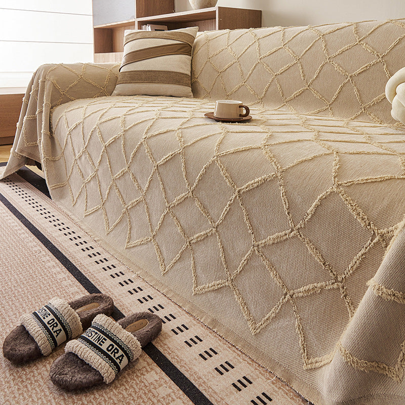 Close view of the tufted Luxe Diamond lattice on the Oat Beige throw over a sofa seat
