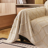 Oat Beige Luxe Diamond throw draped over the sofa arm beside a wood cabinet