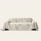Luxe Heritage cream latte sofa throw draped over a couch, front view on an ivory backdrop
