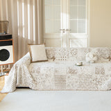 Cream latte Luxe Heritage throw styled on a sofa in a sunlit living room with a boucle cushion and cup
