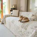Ginger cat resting on the cream latte Luxe Heritage throw draped across a living room couch