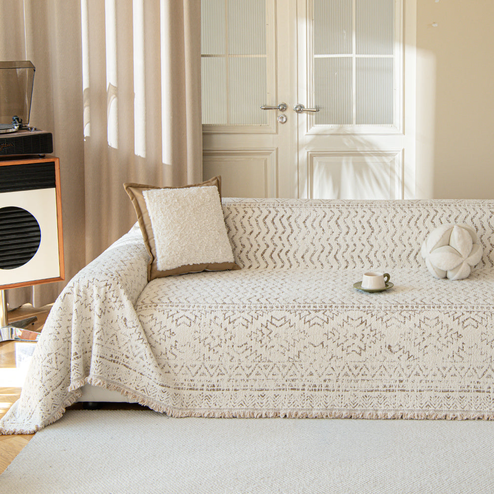 Oat Ivory Luxe Heritage throw styled on a sunlit sofa with boucle and flower cushions