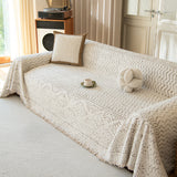 Oat Ivory Luxe Heritage throw draped over a sofa with fringed hem, bright angled view