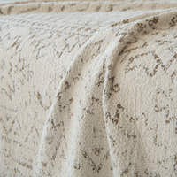 Macro of the Oat Ivory boucle weave showing the subtle Luxe Heritage motif