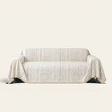 Pearl Beige Luxe Heritage textured throw draped over a two-seat sofa on ivory background