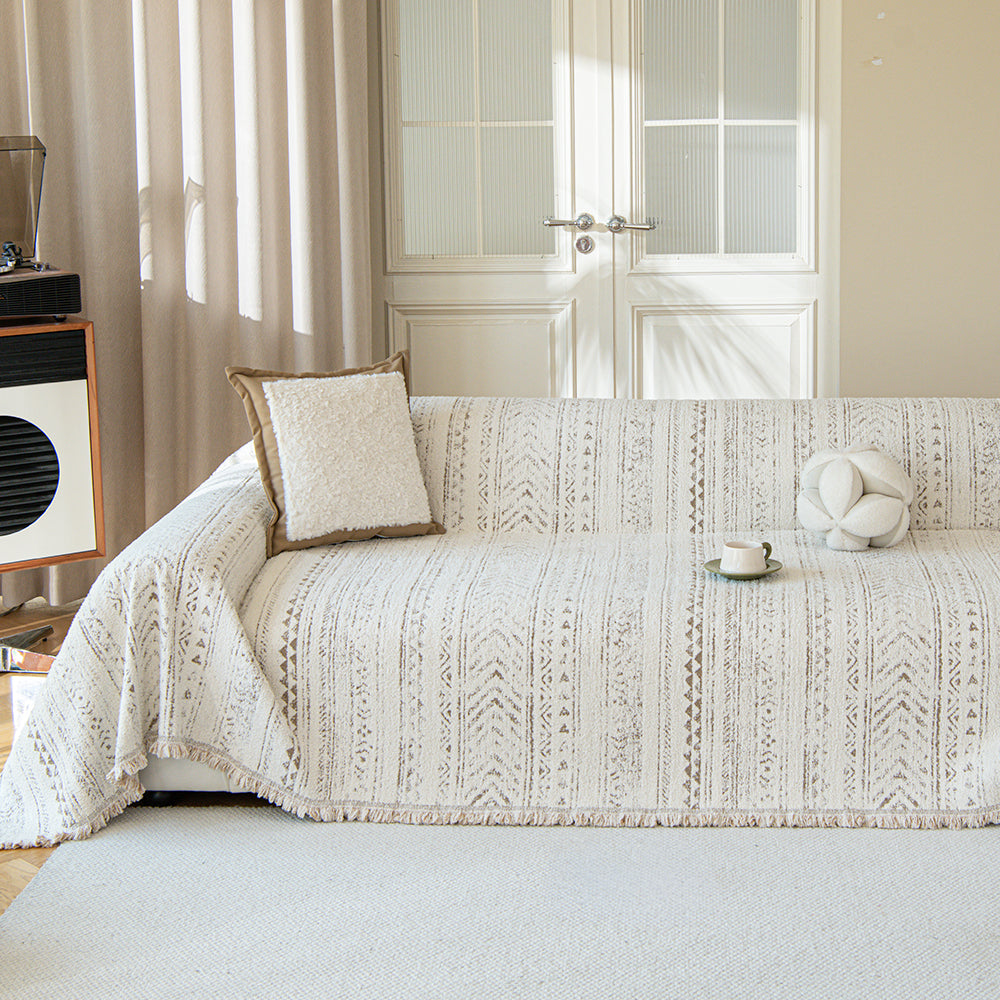 Pearl beige heritage throw covering a sofa with boucle cushion, cup and record player