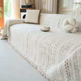 Textured pearl beige throw on a sofa with boucle cushion and coffee cup in a bright room