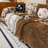 Mocha Pearl Luxe Patchwork throw over a sofa with floral and knot cushions and a teacup