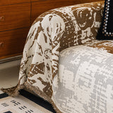 Close-up of Mocha Pearl Luxe Patchwork throw cascading over a sofa corner, patchwork blocks and fringed hem