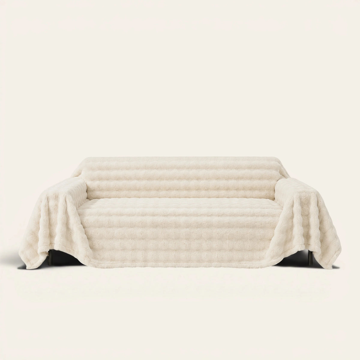 Luxe Ripple faux fur sofa throw in Ivory Luxe draped over a couch, front view on ivory background