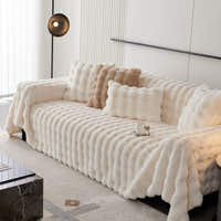 Luxe Ripple throw in Ivory Luxe over a sofa with cushions and pendant light, angle view