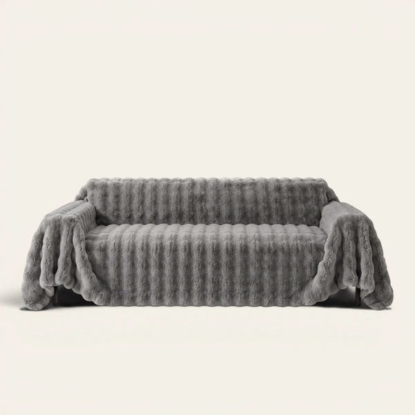 Smoky Quartz Luxe Ripple sofa throw draped over a full couch, front view on ivory background