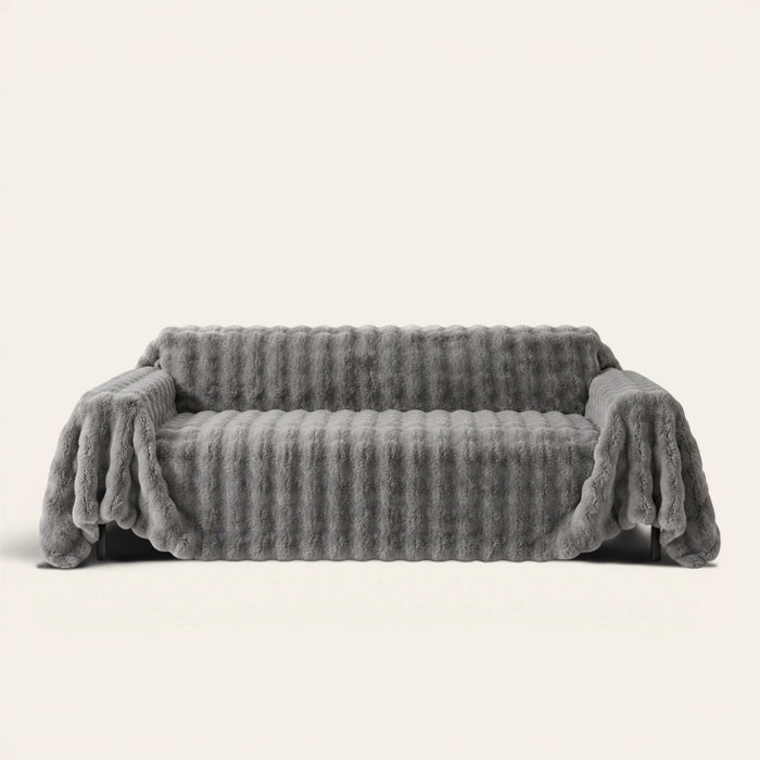 Smoky Quartz Luxe Ripple sofa throw draped over a full couch, front view on ivory background