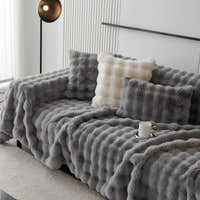 Smoky Quartz Luxe Ripple plush throw over a sofa with light cushions in a modern room