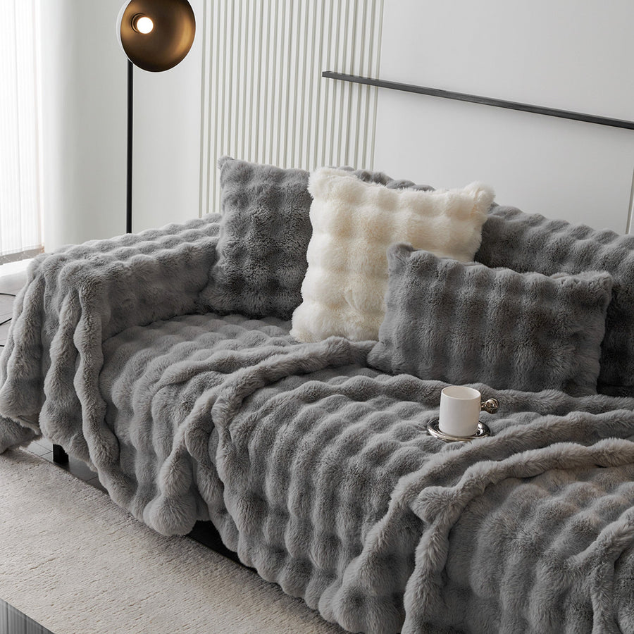 Smoky Quartz Luxe Ripple plush throw over a sofa with light cushions in a modern room