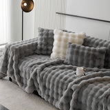 Smoky Quartz Luxe Ripple plush throw over a sofa with light cushions in a modern room