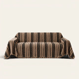 Cafe Noir Metro Stripe sofa throw draped over a three seater sofa, front view on ivory background with fringed hem