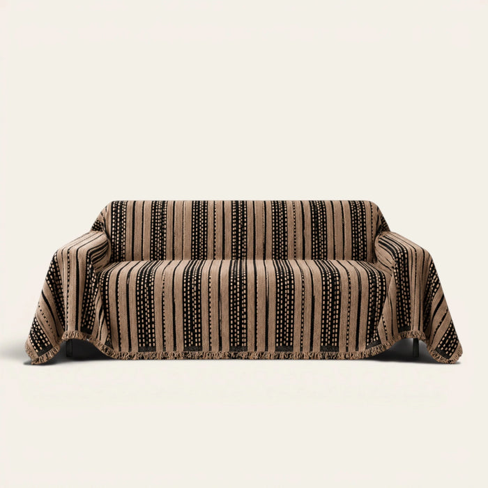 Cafe Noir Metro Stripe sofa throw draped over a three seater sofa, front view on ivory background with fringed hem